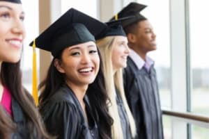 graduates in a row smiling